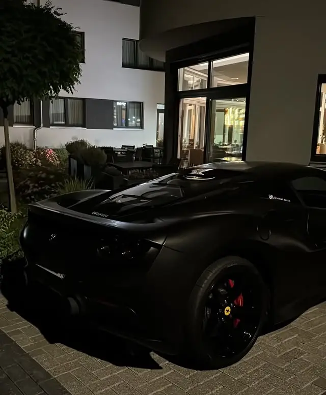 Schwarzer Ferrari vor einem modernen Haus