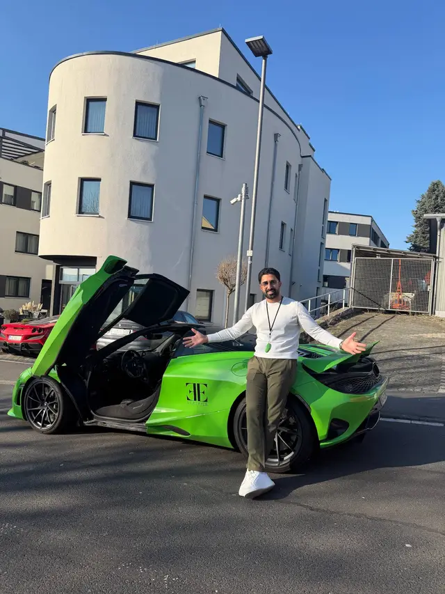 Grüner McLaren mit geöffneten Türen vor einem modernen Gebäude